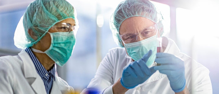 Two researchers discuss the contents of a vial.